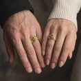 Load image into Gallery viewer, A gold plated koi spinner wedding band is worn on a finger, highlighting the sculpted fish symbolism, flowing wave design, and meaningful meditation ring style in a refined close-up lifestyle shot.