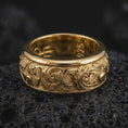 Load image into Gallery viewer, A gold plated koi fish spinner ring rests on rugged volcanic rock, featuring dimensional carp figures, curling ocean waves, and symbolic aquatic detailing in a luxury macro studio close-up.