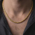 Load image into Gallery viewer, A gold plated 4mm square Byzantine chain necklace is worn on a man with dark clothing, emphasizing its woven link texture and bold statement appeal in a close-up lifestyle image.