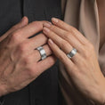 Load image into Gallery viewer, A polished silver Irish wedding band is worn naturally on a hand, highlighting the continuous Celtic knot design, smooth edges, and elegant spinner ring profile in a lifestyle close-up.