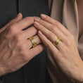 Load image into Gallery viewer, A gold plated Celtic knot ring is worn on a hand, emphasizing the symbolic interwoven pattern, wide spinning band form, and meaningful Irish-inspired jewelry design.