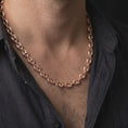 Load image into Gallery viewer, The rose gold plated Mariner chain necklace is worn around a man's neck, showcasing the substantial 11mm width, smooth puffed anchor links, and distinctive nautical-inspired men's jewelry design.