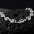 Load image into Gallery viewer, The polished silver 11mm Mariner bracelet is displayed on textured black volcanic rock, highlighting the smooth puffed anchor links, reflective surfaces, and bold wide-link construction in a premium macro photograph.