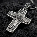 Load image into Gallery viewer, An oxidized sterling silver Pope Francis cross pendant rests on dark volcanic rock, featuring the Good Shepherd carrying a sheep, surrounding flock, dove symbol, and detailed recessed Christian imagery in a macro studio close-up.