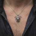Load image into Gallery viewer, An oxidized sterling silver ant head necklace is worn on a man's chest, displaying the textured insect eyes, segmented antennae, large mandibles, and darkened sculptural details in a close-up lifestyle photograph.