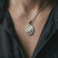 Load image into Gallery viewer, The polished silver swan necklace is worn naturally on the chest, showing the sculpted bird, elegant curved neck, detailed feather pattern, and timeless sterling silver nature jewelry style.