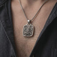 Load image into Gallery viewer, Oxidized sterling silver Tlaloc necklace worn on the chest, displaying the recognizable ringed eyes, fanged mouth, and detailed Mexica-inspired geometric design.