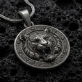 Load image into Gallery viewer, Oxidized sterling silver roaring tiger pendant on black volcanic rock, featuring a detailed tiger head, open mouth, sharp fangs, striped fur, and ornate circular border.