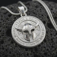 Load image into Gallery viewer, Polished sterling silver Odin necklace displayed on dark volcanic stone, highlighting the horned Viking helmet, engraved symbols, circular medallion frame, and warrior design.