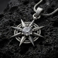 Load image into Gallery viewer, Oxidized sterling silver Gale's Earring inspired pendant on black volcanic rock, featuring an eight-point starburst design and a large clear faceted center stone.