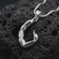 Load image into Gallery viewer, The polished silver scorpion tail necklace is displayed on textured black volcanic rock, highlighting the sculptural segmented body, pointed stinger, dimensional construction, and sleek sterling silver finish in a premium macro photograph.