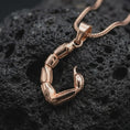 Load image into Gallery viewer, The rose gold plated Scorpio tail necklace is arranged on black volcanic rock, emphasizing the segmented sculptural form, pointed stinger, and distinctive zodiac-inspired statement pendant design in a refined macro image.