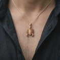 Load image into Gallery viewer, The rose gold plated scorpion pendant is worn on the chest, showcasing the sculptural claws, detailed legs, armored body, raised stinger, and bold unisex astrology-inspired jewelry style.