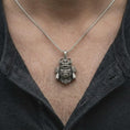 Load image into Gallery viewer, An oxidized sterling silver gorilla samurai necklace worn on a man's chest, displaying the fierce gorilla face, curved helmet horns, intricate Japanese-inspired armor, and rugged men's jewelry style.
