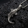 Load image into Gallery viewer, Oxidized sterling silver Japanese koi fish pendant on black volcanic rock, featuring engraved diamond scales, flowing fins, a curved body, and detailed fish tail.
