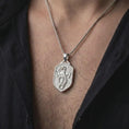 Load image into Gallery viewer, Polished silver coiled dragon pendant worn on the chest, featuring detailed wings, scaled serpentine body, curled tail, and a distinctive mythical creature shield design.