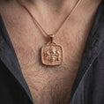 Load image into Gallery viewer, Rose gold plated Aztec skull necklace worn on the chest, showcasing jaguar imagery, sculpted skulls, feathered ornamentation, and a distinctive Mesoamerican statement design.