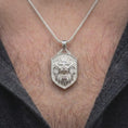 Load image into Gallery viewer, Polished silver lion head pendant worn on the chest, featuring a three-dimensional roaring lion face, sculpted fur, textured shield background, and powerful masculine jewelry design.