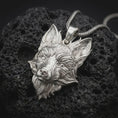 Load image into Gallery viewer, Polished sterling silver fox necklace displayed on dark volcanic stone, highlighting the realistic fox face, upright ears, layered fur details, and dimensional animal design.