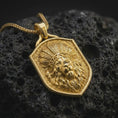 Load image into Gallery viewer, Gold plated lion chief necklace resting on black textured stone, featuring a raised lion head with an elaborate feathered headdress, detailed facial features, flowing mane, and shield-shaped silver pendant design.
