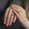Load image into Gallery viewer, Oxidized 925 sterling silver matching rose flower rings worn on the fingers of a man and woman together, featuring raised rose blossoms, detailed petals, dark recessed floral engravings, and coordinated oxidized silver finishes.