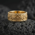 Load image into Gallery viewer, Gold plated 925 sterling silver Viking Valknut ring displayed on dark volcanic rock, featuring raised interlocking triangle symbols, repeating Nordic geometric patterns, smooth band edges, and a warm polished gold finish.