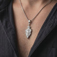 Load image into Gallery viewer, Polished 925 sterling silver matching dragon sword necklaces worn by a man and woman together, showcasing detailed winged dragons, curled tails, ornamental sword handles, Gothic-inspired blade designs, and matching bright polished silver finishes.