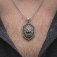 Load image into Gallery viewer, Oxidized sterling silver roaring lion necklace worn on the chest, showing the fierce lion portrait, detailed flowing mane, sharp fangs, and bold shield-shaped animal pendant.