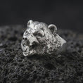 Load image into Gallery viewer, Polished 925 sterling silver 3D bear ring resting on black volcanic stone, showcasing a fierce roaring bear head with lifelike facial features, sculpted fur, prominent canine teeth, powerful jaws, and bright polished silver finish.