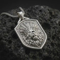 Load image into Gallery viewer, Polished sterling silver lion headdress pendant displayed on dark volcanic rock, highlighting the three-dimensional lion portrait, layered ceremonial feathers, expressive eyes, detailed muzzle, and sculpted mane.