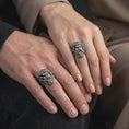 Load image into Gallery viewer, Oxidized 925 sterling silver matching Poseidon rings worn on the fingers of a man and woman together, featuring sculpted Greek god faces, detailed wavy beards, flowing hair, and contrasting dark oxidized silver finishes.