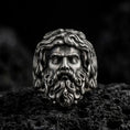 Load image into Gallery viewer, Oxidized 925 sterling silver Poseidon ring displayed on black volcanic rock, featuring a three-dimensional Greek sea god face with flowing wavy hair, deeply sculpted beard, prominent eyebrows, and dark recessed details.