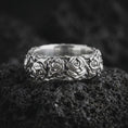 Load image into Gallery viewer, Polished 925 sterling silver rose floral ring resting on black volcanic stone, showcasing raised rose blossoms, intricately sculpted petals, delicate botanical foliage, and a bright polished silver finish.