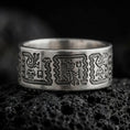 Load image into Gallery viewer, Oxidized 925 sterling silver Aztec Mayan ring displayed on black volcanic rock, featuring intricate Mesoamerican-inspired figures, stepped geometric patterns, dark recessed engravings, and a wide silver wedding band.