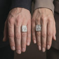 Load image into Gallery viewer, Polished Silver Saint Peter and Paul signet rings worn by a man and woman together, highlighting the sculpted saints and ornate silver band design.