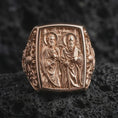 Load image into Gallery viewer, Rose Gold Plated Saint Peter and Paul Catholic ring resting on black volcanic rock, featuring detailed religious relief and a raised rectangular frame.