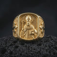 Load image into Gallery viewer, Gold plated 925 sterling silver Saint Nicholas signet ring displayed on textured black volcanic rock, featuring the Catholic bishop with detailed religious robes, bishop's crozier, book with three symbolic balls, engraved cross shoulders, and warm gold plated finish.