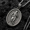 Load image into Gallery viewer, Oxidized Silver Saint Paul Apostle pendant on black volcanic rock, featuring the haloed saint holding a sword and book in detailed relief.