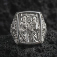 Load image into Gallery viewer, Polished Silver Saint Peter and Paul ring on black volcanic rock, highlighting the rectangular signet face, architectural background, and ornate side engravings.
