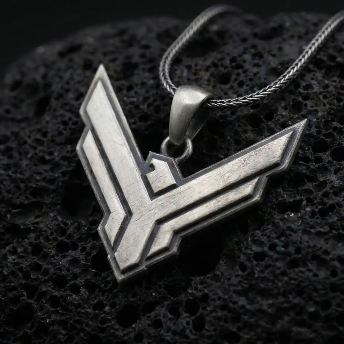 Oxidized sterling silver House Atreides pendant on black volcanic rock, featuring the angular hawk emblem, layered geometric edges, and bold Dune inspired design.