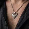 Load image into Gallery viewer, Oxidized sterling silver House Atreides necklace worn on the chest, showing the angular hawk emblem, dark recessed details, and bold Dune inspired pendant profile.
