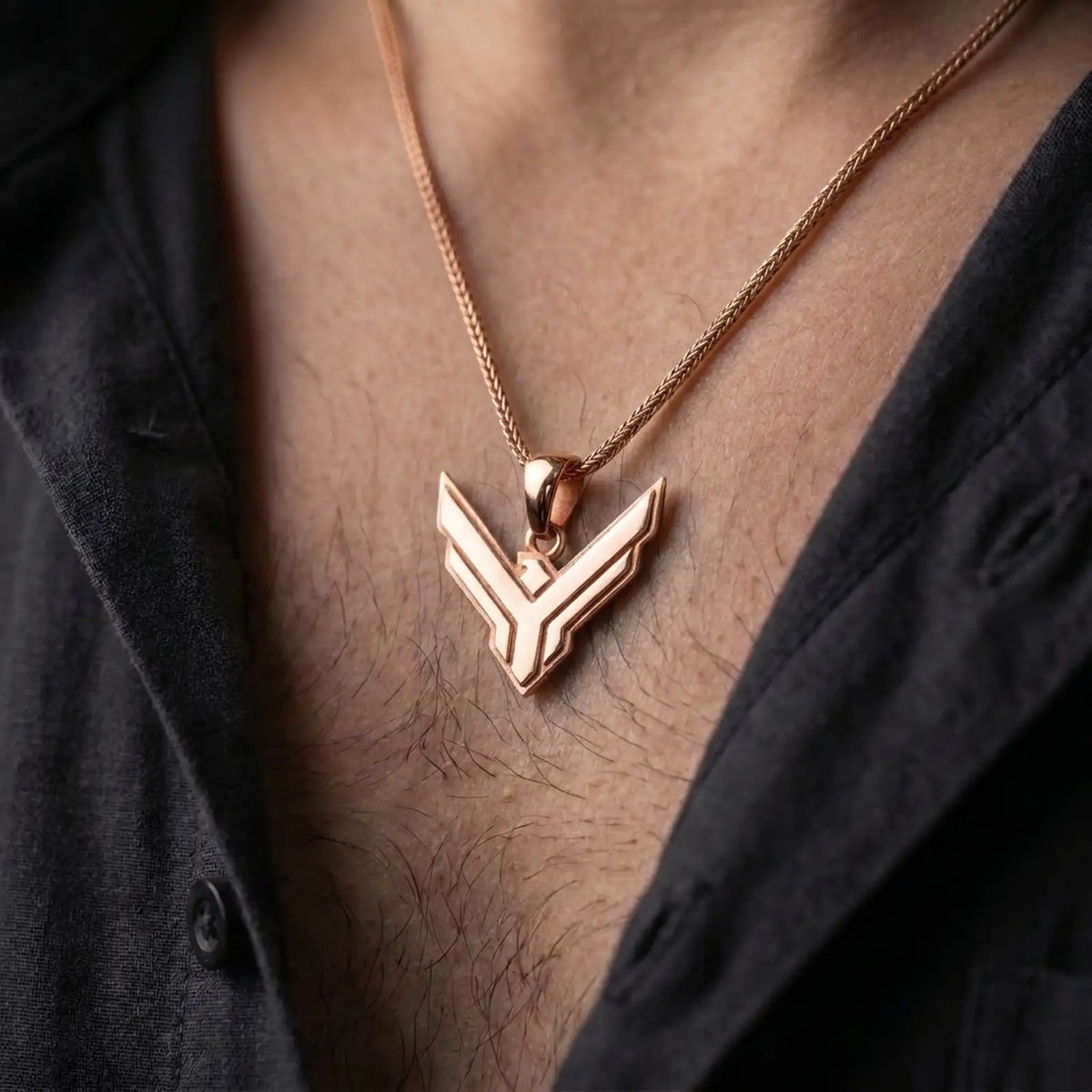 Rose gold plated House Atreides pendant worn on the chest, showcasing the stylized hawk symbol, layered geometric details, and distinctive Dune inspired aesthetic.