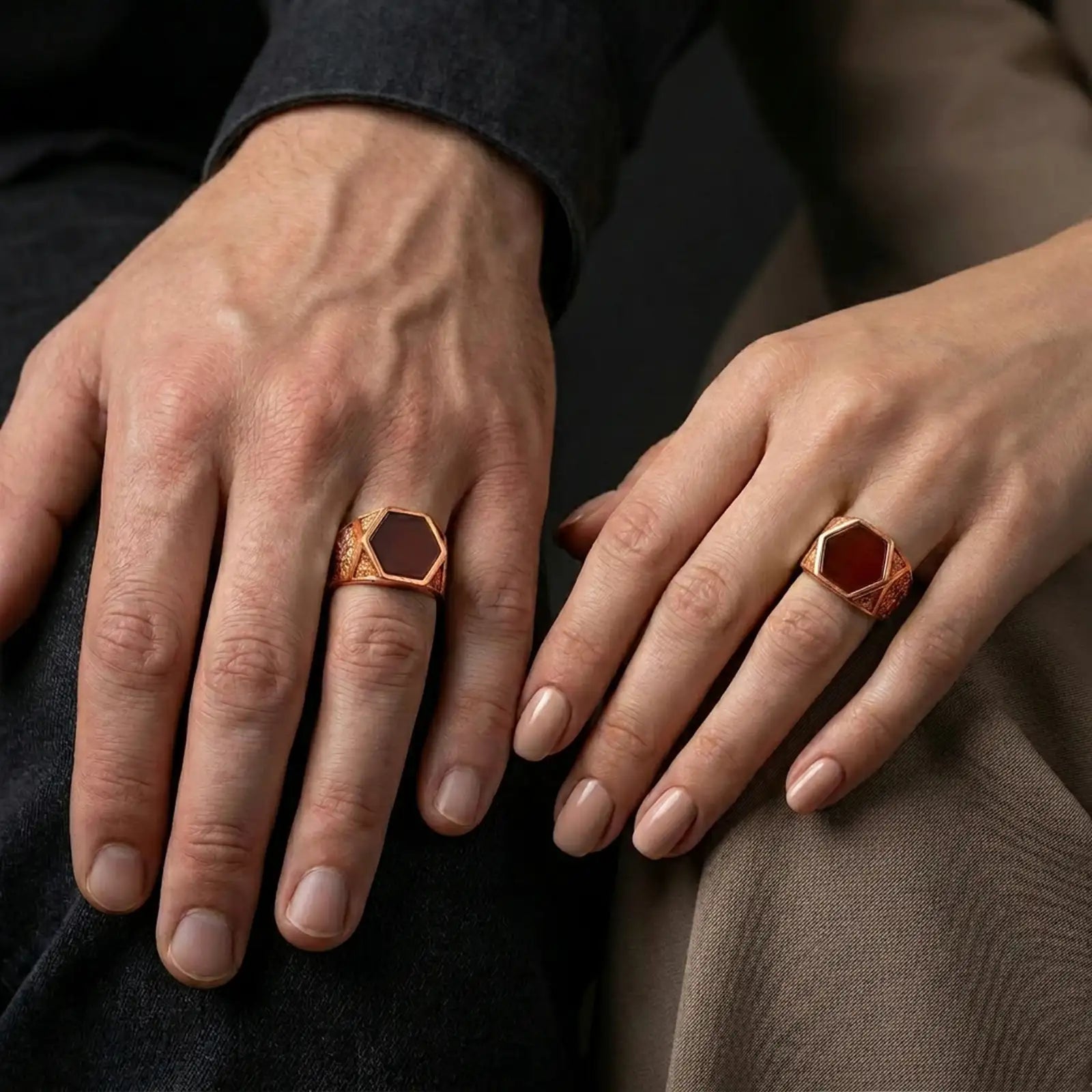 A red onyx signet ring in a rose gold plated finish worn on a finger in a clean lifestyle close-up.