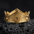 Load image into Gallery viewer, 
Gold plated Targaryen dragon ring on textured volcanic rock, premium close-up studio composition emphasizing the dragon sigil, angular ring face, and medieval 
