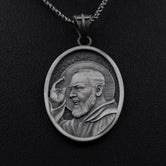 Close-up of 925 sterling silver Padre Pio pendant necklace on black background