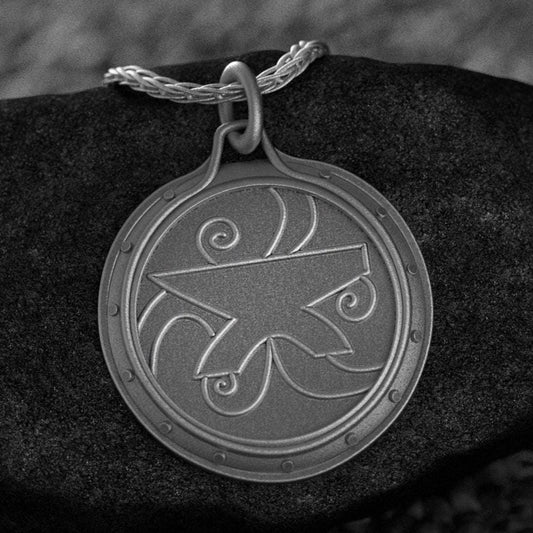 Oxidized sterling silver Amulet of Zenithar pendant on black rock background.