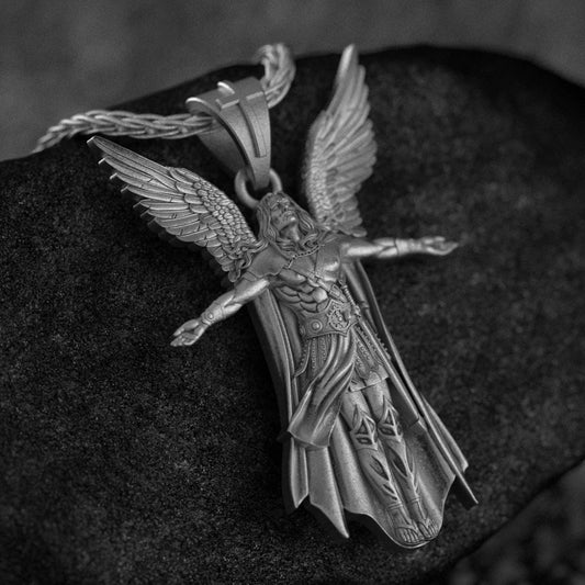 Oxidized silver archangel pendant with armor and wings on black stone background,