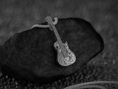 Oxidized silver skull guitar pendant with music-themed design,