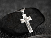 Polished silver conceptual cross pendant with female symbolism and textured design,