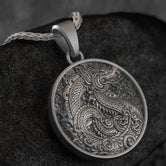 Close-up of round gold dragon medallion necklace with embossed fantasy motif,